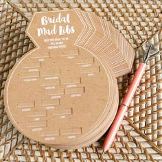 a round wooden coaster sitting on top of a woven table cloth next to a pen