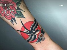 an arm with a bird and flower tattoo on it