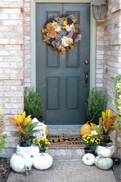 a front door decorated for fall with pumpkins and flowers