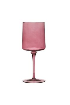 a pink wine glass sitting on top of a table