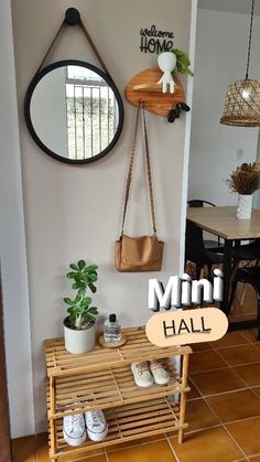 a wooden bench sitting under a mirror next to a potted plant