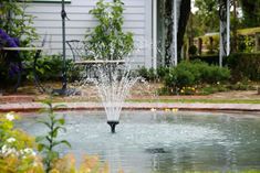 a water fountain in the middle of a garden