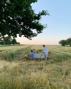 two people sitting at a table in a field