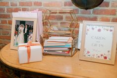 a table topped with pictures and gifts next to a brick wall