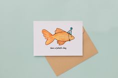 a card with an orange fish wearing a birthday hat