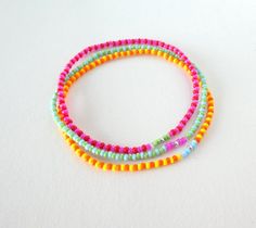 three different colored beads on a white surface