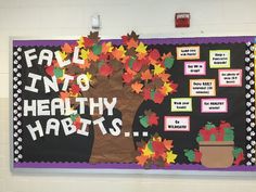 a bulletin board with fall into healthy habitts written on it in front of a classroom wall