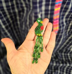 Expertly crafted with intricate beadwork, these Large Beaded Quetzal Earrings embody the beauty and culture of Guatemala. The dainty green and red design adds a stunning touch to any outfit, making them a unique and elegant accessory for any occasion. Embrace the unparalleled craftsmanship and representation of Guatemalan culture with these stylish earrings. Measurements: 4.5 inches long 0.90 inches wide Handwoven Green Jewelry For Festival, Green Handwoven Jewelry For Festival, Unique Handwoven Green Earrings, Artisan Green Beaded Earrings With Dangling Beads, Artisan Green Beaded Dangling Earrings, Green Beaded Dangle Earrings For Festive Occasions, Traditional Green Beaded Jewelry, Green Bohemian Handwoven Jewelry, Bohemian Green Handwoven Jewelry