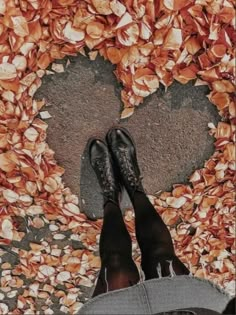 a person standing in front of a heart shaped rock wall with their feet on the ground