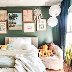 a bedroom with green walls and pictures on the wall above the bed, along with stuffed animals