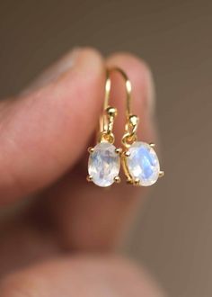 Our Moonstone Dangle Earrings in 18k gold vermeil are just the right size to be noticed and small enough to wear all day comfortably. The stone is a large 7mm x 5mm natural blue flash genuine oval Moonstone, set in a sturdy prong setting. A classic with a touch of modern, also available in sterling silver. Sold as a pair, comes with extra silicone ear backs to keep them secure.DETAILS• Dimensions: Stone - 7mm x 5mm, total length - 22mm• Weight - 0.7 g• Material - 925 sterling silver, 18k thick g Minimalist Moonstone Jewelry With Ear Wire, Dainty Moonstone Earrings For Everyday, White Dangle Earrings With Ethical Gemstones, Delicate 14k Gold Gemstone Earrings, Minimalist Gold-plated Gemstone Earrings, Minimalist Gold Plated Gemstone Earrings, Minimalist Gold Gemstone Earrings, Dainty 14k Gold Gemstone Earrings, Minimalist Moonstone Earrings For Anniversary