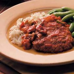 a white plate topped with meat and green beans