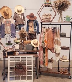 hats and clothing are on display in a room with metal shelving, shelves, and tables