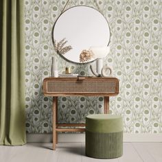 a mirror sitting on top of a wooden table next to a green stool and curtain