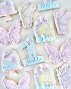 decorated cookies are arranged in the shape of butterfly wings and numbers for first birthdays