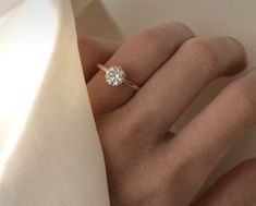 a woman's hand with a diamond ring on it