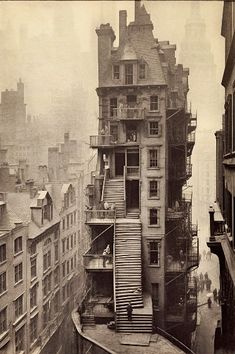 an old photo of a city street with fire escapes