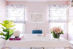 a white desk with flowers and books on it