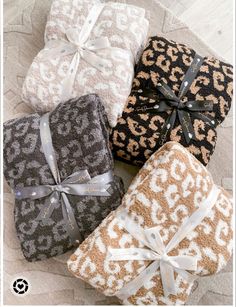 four towels wrapped in leopard print and tied with ribbon