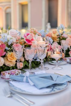 the table is set with flowers, candles and napkins for an elegant wedding reception