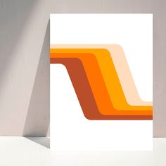 an orange and white abstract art print on a wall next to a vase with a plant in it