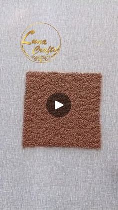 a close up of a piece of cloth with a video playing button in the center