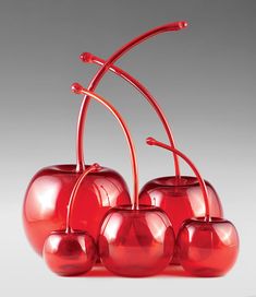 four red glass cherries on a white background