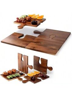 two pieces of puzzle sitting on top of a wooden table with fruit and other items