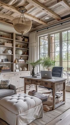 a living room filled with lots of furniture next to a large window covered in wooden beams