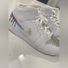 This Is A Pair Of Size 7y (Fits Like An 8.5 Adult) Jordan 1 Mid Triple White Sneakers With Customized Crystal Ombr Blue And Purple On The Swoosh And Vamp. Missing A Couple Of Crystals As Shown And Honestly Can’t Tell Unless Scrutinizing It. Worn Only Once!! Super Cute For Any Party, Event, Mitzvah Etc. Jordan 1 Mid Triple White, Shoes Jordan 1, Custom Kicks, Nike Shoes Jordans, Shoes Jordan, Jordan 1 Mid, Blue Ombre, Nike White, Kids Nike