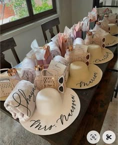 several hats are lined up on a table with the names of people and their families