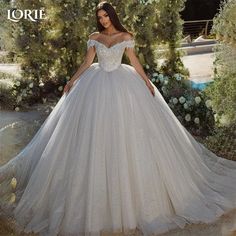 a woman in a white wedding dress posing for the camera with her hands on her hips