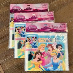 three disney princess treat bags on a wooden table