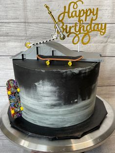 a black and white birthday cake with a skateboard on top that says happy birthday