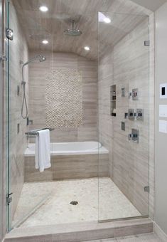 a walk in shower sitting next to a white bath tub under a sky light fixture