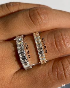 two rings with different sizes and widths on each ring, one has three stones in it