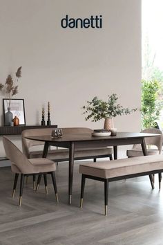 a dining room table with chairs and bench in front of a wall that reads daneti