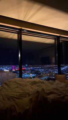 a bedroom with a view of the city at night