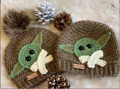 two knitted baby yoda hats with pine cones