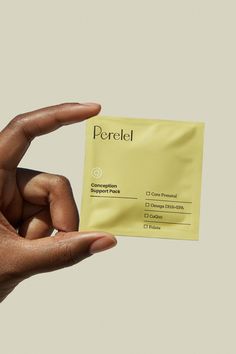 a person holding up a piece of yellow paper with the word perkel on it