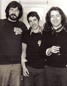 three men standing next to each other holding glasses in their hands and smiling at the camera