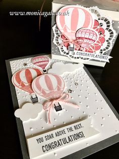 two cards with hot air balloons and congratulations written on the front, one in pink