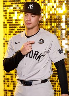 a baseball player poses for a photo in front of a wall with gold sequins