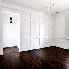 an empty room with white paneling and wood floors is seen in this image from the inside