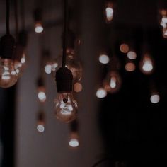 several light bulbs hanging from the ceiling in a dark room with blurry lights around them