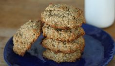 a stack of oatmeal cookies on a blue plate next to a glass of milk