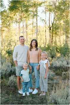 a family posing for a photo in the woods