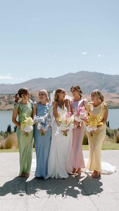 a group of women standing next to each other on top of a cement floor covered field