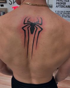 the back of a man's upper body with a spider - man tattoo on it