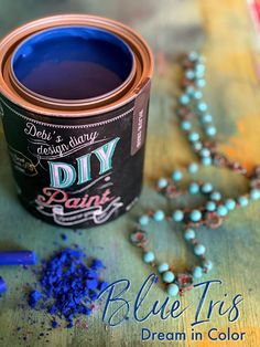 a can of blue paint next to some beads